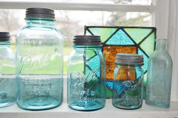 Blue canning jars in a kitchen window. The kitchen in the home tour of our old house.