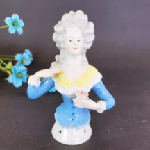 Antique half doll. 5" court lady with blue lace-up top. Open arms.