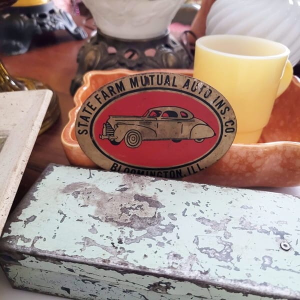 1930s State Farm Auto tag badge, Fire King mug and a small, metal tool box, all found at an estate sale.